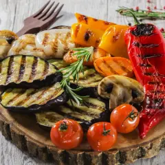 Pyszne przekąski na grilla: grillowany bakłażan, papryka, pieczarki, pomidorki i cebula, udekorowane rozmarynem.