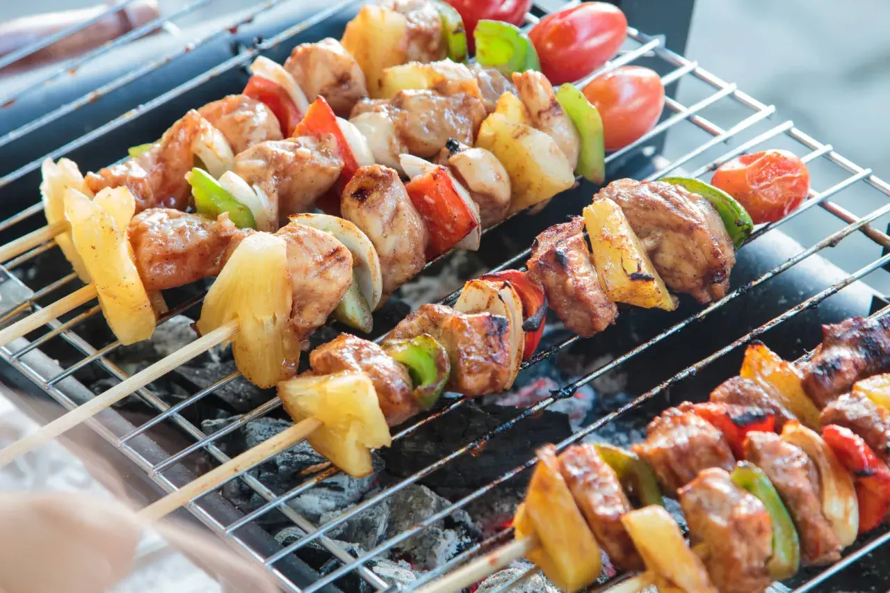 Szaszłyki drobiowe z ananasem, papryką i pomidorkami na grillu.
