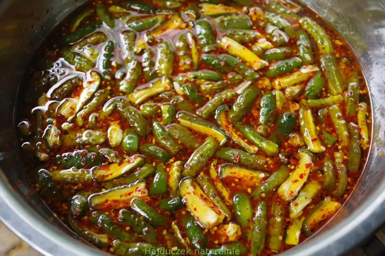 Kawałki ogórków krokodylków w pikantnej zalewie z chili i przyprawami, gotowe do marynowania.